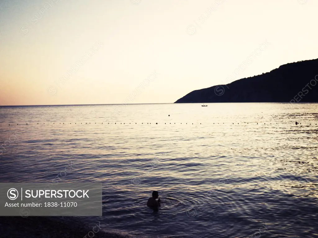 Lone Person Swimming in Calm Sea at Sunset, Croatia