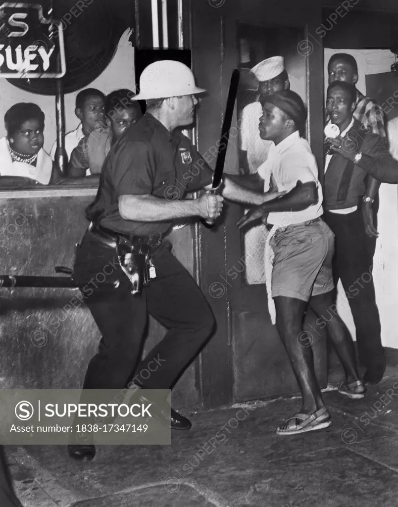 Policeman confronts group of People after night of rioting due to fatal shooting of Teen James Powell by Police Officer Lt. Thomas Gilligan, 126th St. and Seventh Avenue, Harlem, New York City, New York, USA, Dick De Marsico, World Telegram & Sun, July 1964