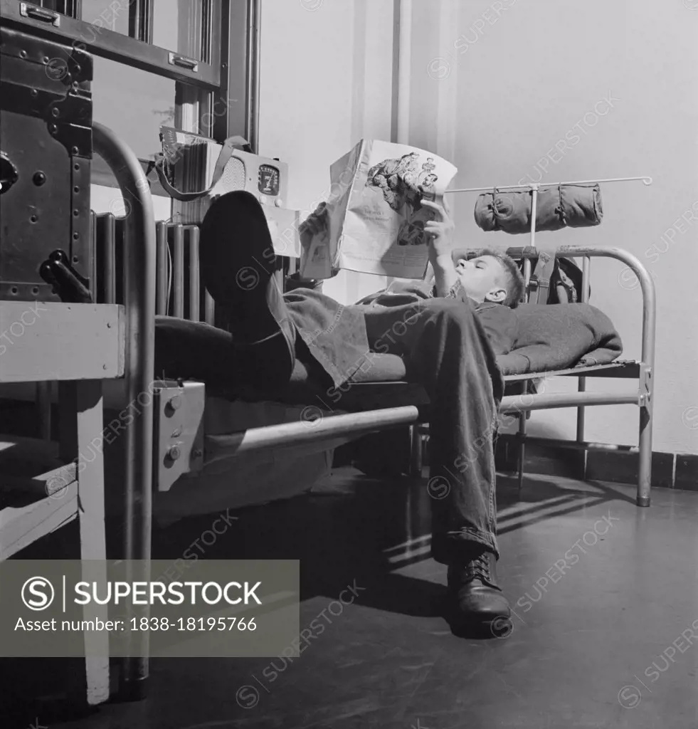 Sergeant George Camblair reading an article in a magazine while relaxing after dinner, Fort Belvoir, Virginia, USA, Jack Delano, U.S. Office of War Information, September 1942