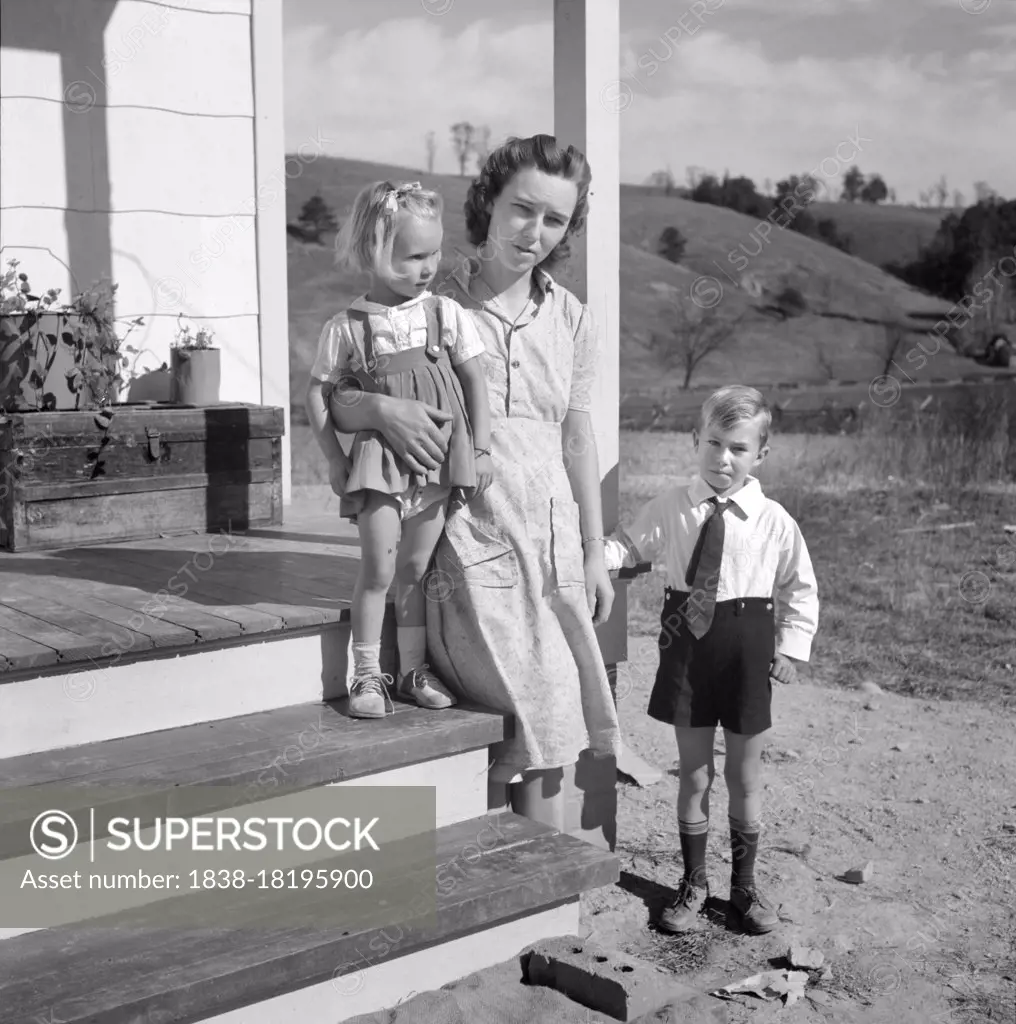 Mr. Howard H. Smith with her children Elsie Marie and Howard Jr., on porch of new rural home built for them on J.T Holley's property by U.S. Farm Security Administration, Riner, Virginia, USA, Marion Post Wolcott, U.S. Farm Security Administration, October 1941