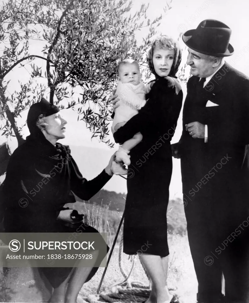 Josette Day (standing holding baby), Fernand Charpin (left), on-set of the French Film, "The Well-Digger's Daughter", French: "La Fille du puisatier", Siritzky International Pictures, U.S. release 1940