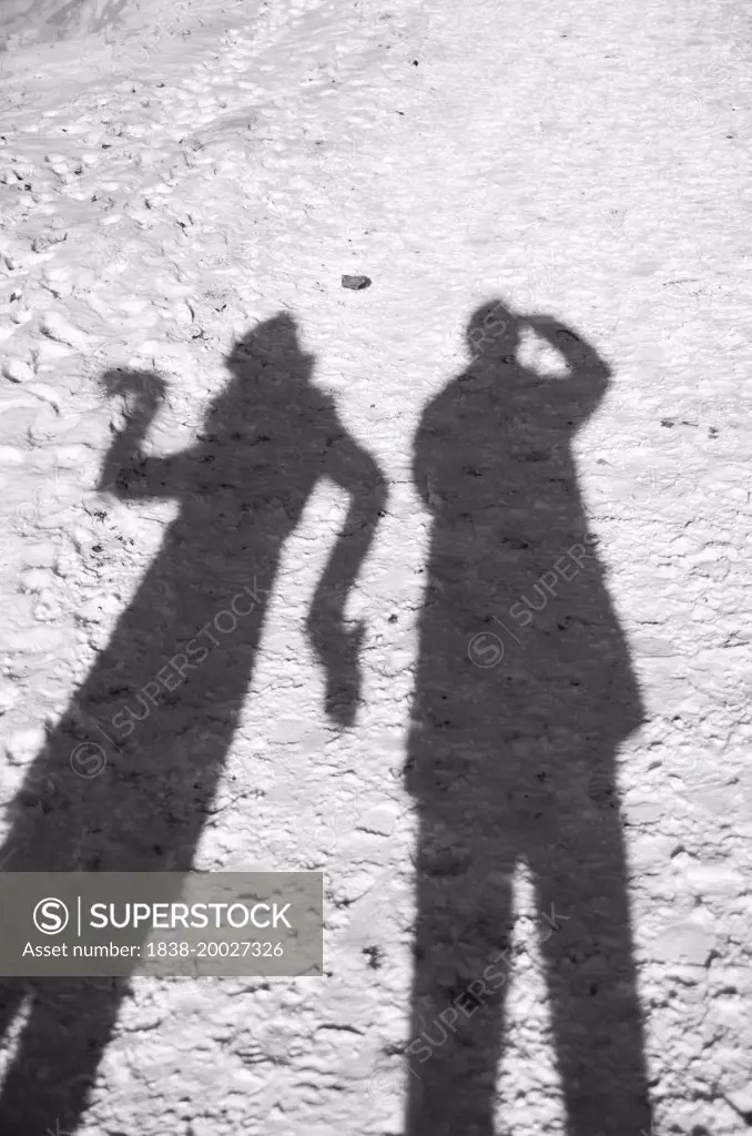 Couple Casting Long Shadows on Snowy Ground, Woman Striking Silly Pose