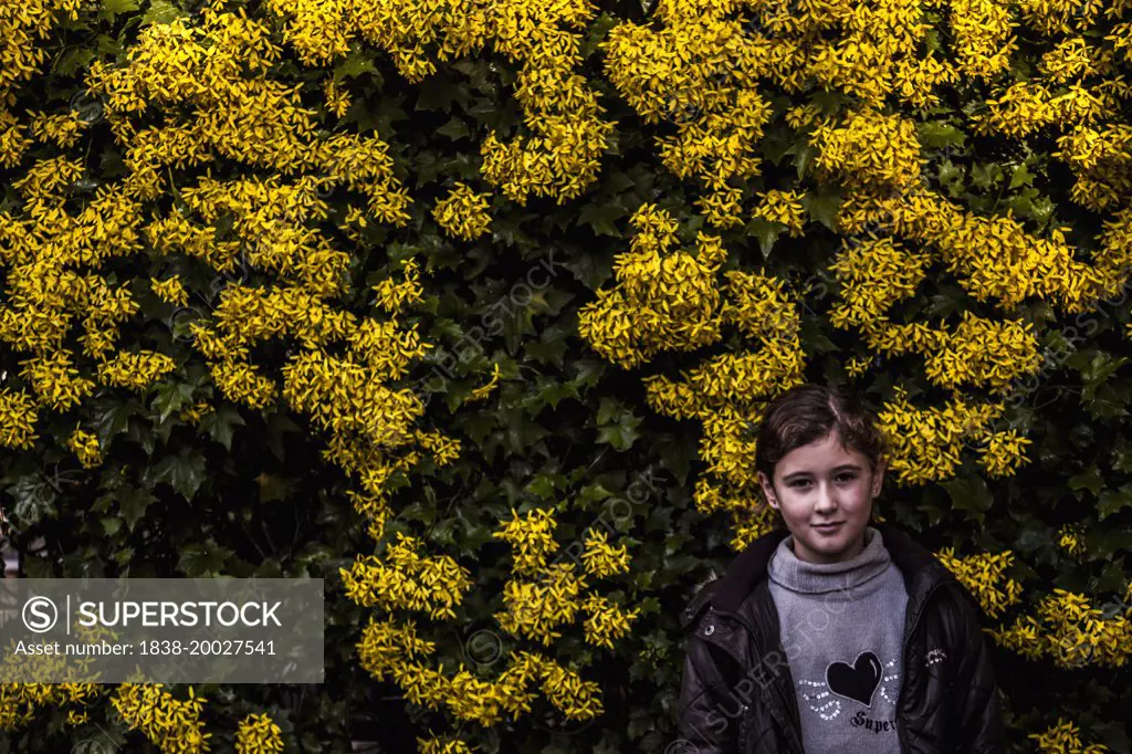 Young Smiling Girl Portrait Against Yellow Flowers