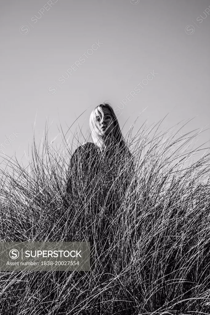 Portrait of Sad Woman Standing Behind Tall Grass