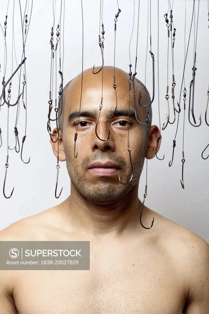 Portrait of Balding Man Surrounded by Hanging Fish Hooks
