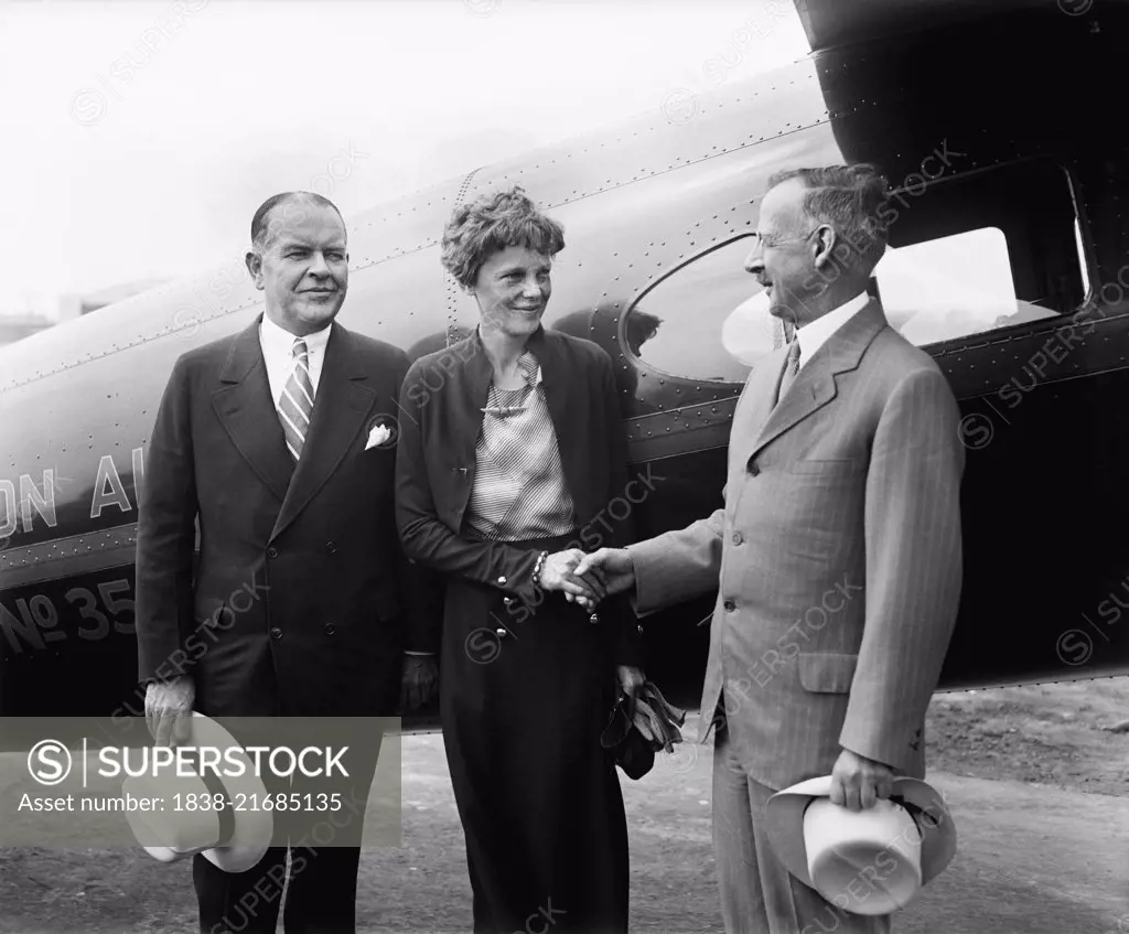 Amelia Earhart, Center, Portrait Shaking Hands with Man in front of Airplane, Harris & Ewing, 1932