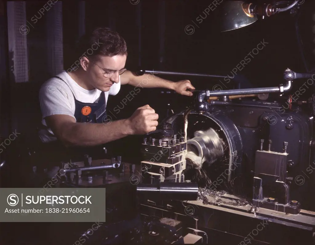 Worker in Machine Shop Finishing Aircraft Part on Huge Turret Lathe, North American Aviation, Inc., Inglewood, California, USA, Alfred T. Palmer for Office of War Information, October 1942