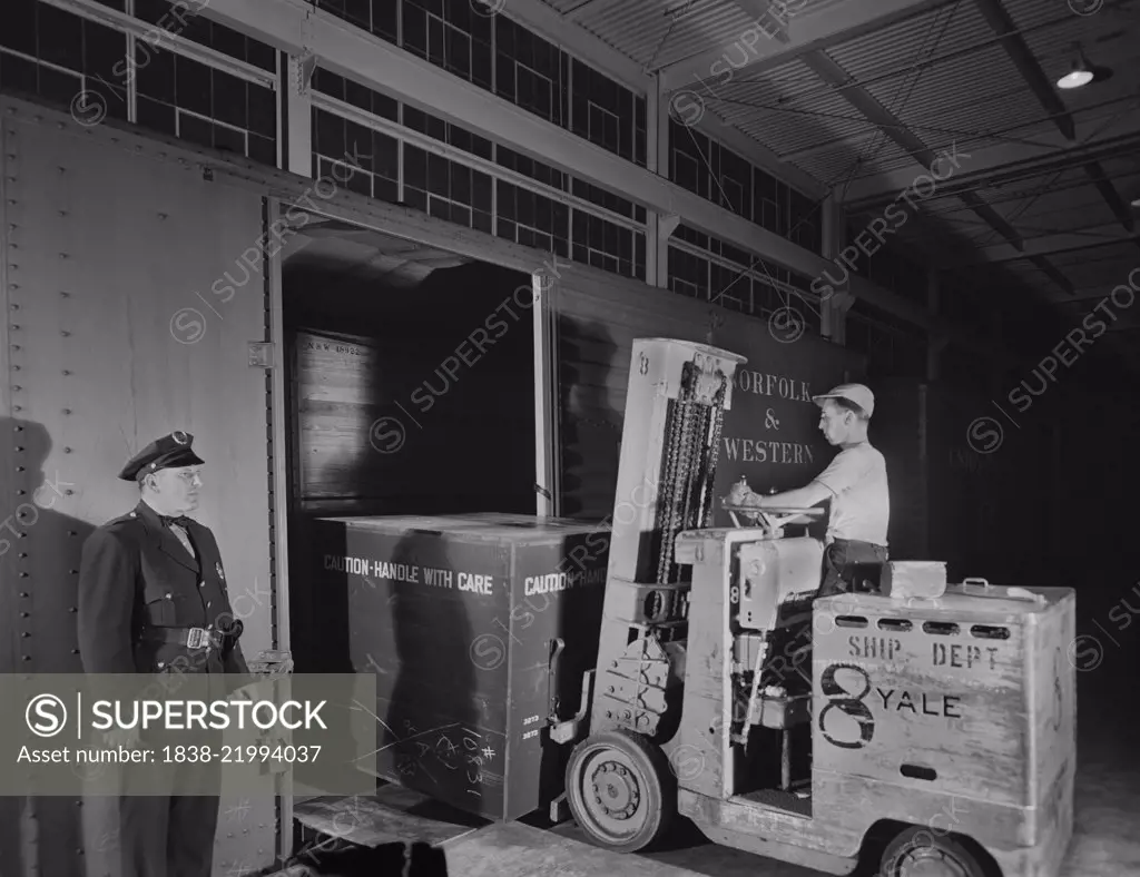 Airplane Motor is Loaded on Freight Car from Platform of Manufacturing Plant, Pratt & Whitney, East Hartford, Connecticut, USA, Andreas Feininger for Office of War Information, June 1942