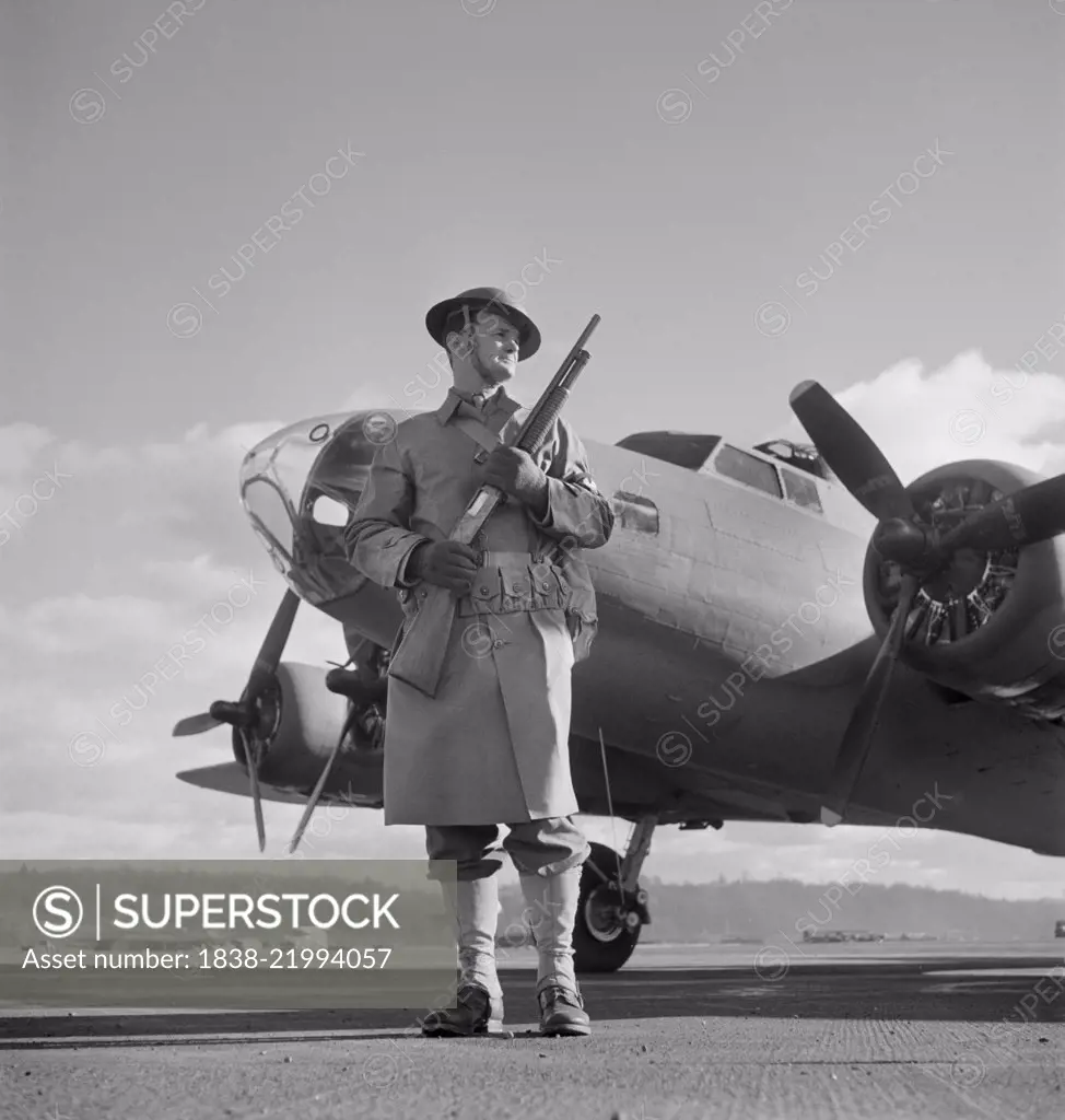 Army Sentry Guarding new B-17F (Flying Fortress) Bombers at Airfield of Boeing Plant, Seattle, Washington, USA, Andreas Feininger for Office of War Information, December 1942