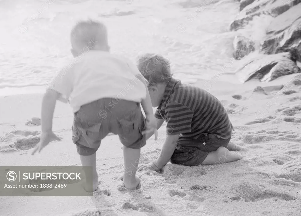 Two Little Boys Playing in Sand 