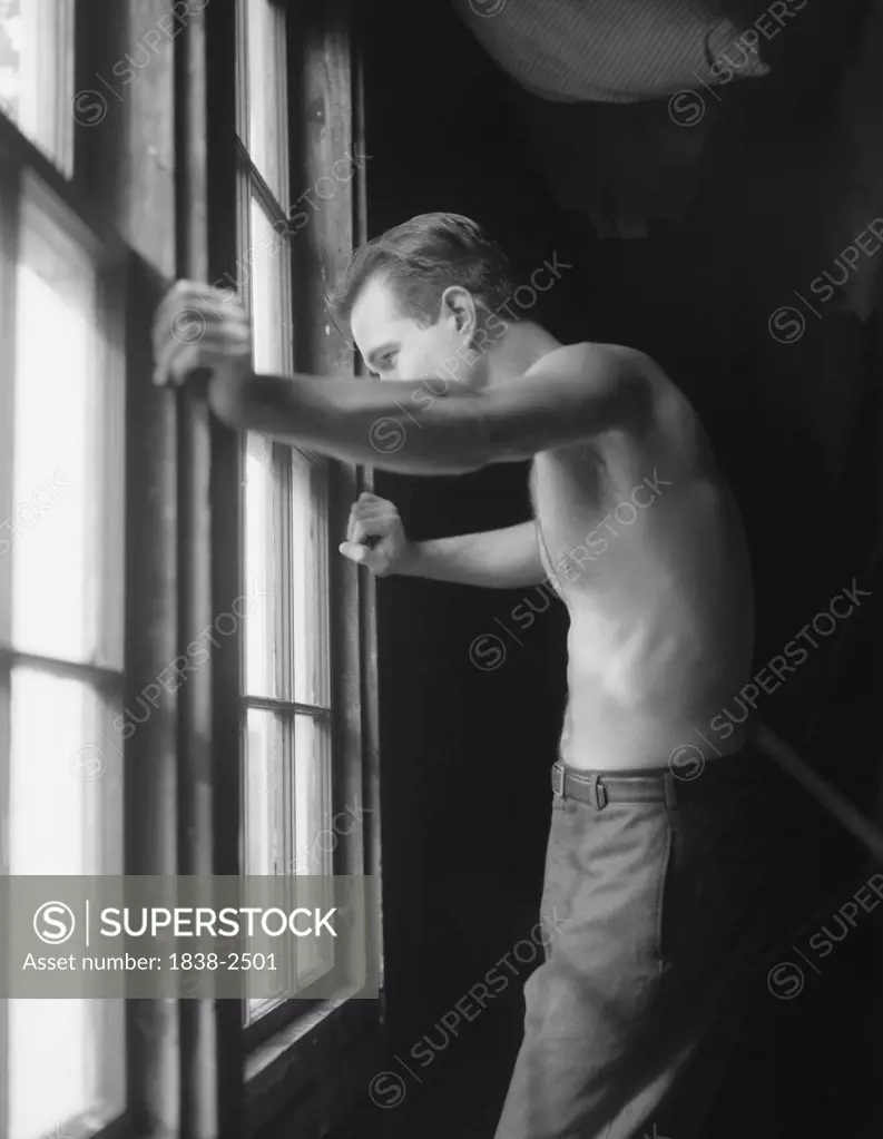 Shirtless Man Leaning on Window 