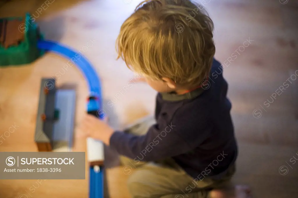 Young Boy Playing with Toy Train