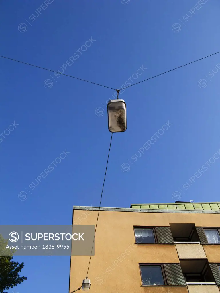 Street Light and Wires  Attached to Building Against Blue Sky, Low Angle View