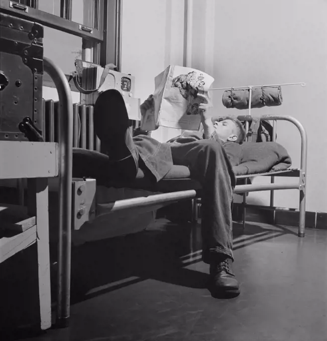Sergeant George Camblair reading an article in a magazine while relaxing after dinner, Fort Belvoir, Virginia, USA, Jack Delano, U.S. Office of War Information, September 1942