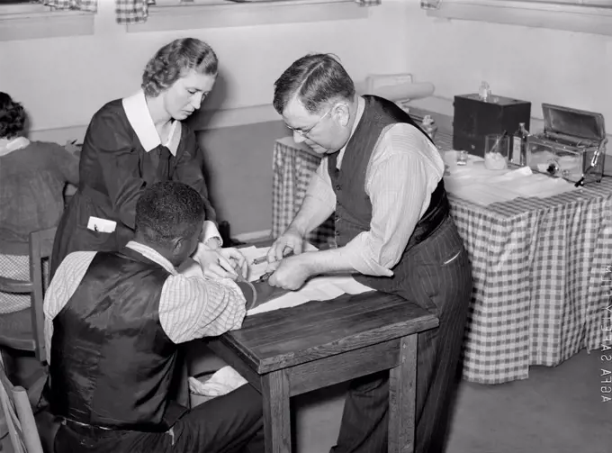 Miss Teal, Nurse, and Doctor W.R. Stanley giving treatment in Venereal Disease Clinic. Enterprise, Alabama, USA, Marion Post Wolcott, U.S. Farm Security Administration, April 1939
