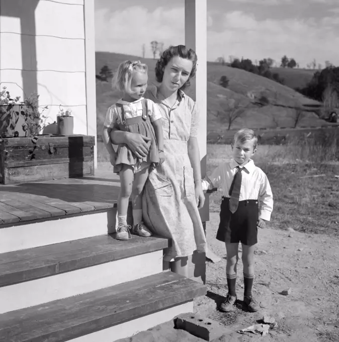 Mr. Howard H. Smith with her children Elsie Marie and Howard Jr., on porch of new rural home built for them on J.T Holley's property by U.S. Farm Security Administration, Riner, Virginia, USA, Marion Post Wolcott, U.S. Farm Security Administration, October 1941