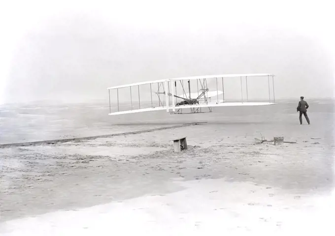 Wilbur Wright lying on machine, Orville Wright running alongside to balance machine, during first powered, controlled, sustained flight, Kitty Hawk, North Carolina, USA, Wilber Wright, Orville Wright, December 17, 1903