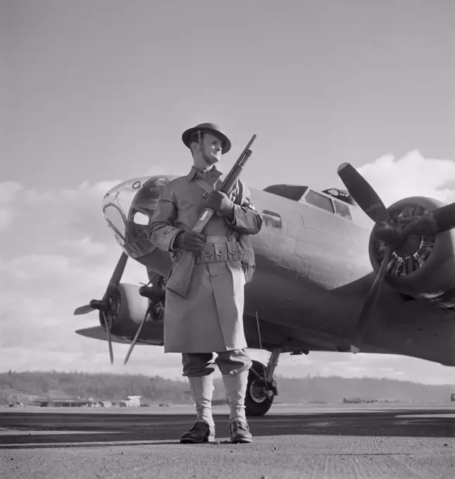 Army Sentry Guarding new B-17F (Flying Fortress) Bombers at Airfield of Boeing Plant, Seattle, Washington, USA, Andreas Feininger for Office of War Information, December 1942