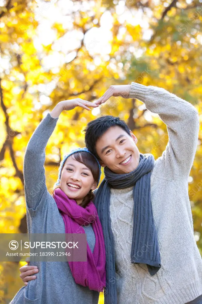 Young Couple Making a Heart with their Arms