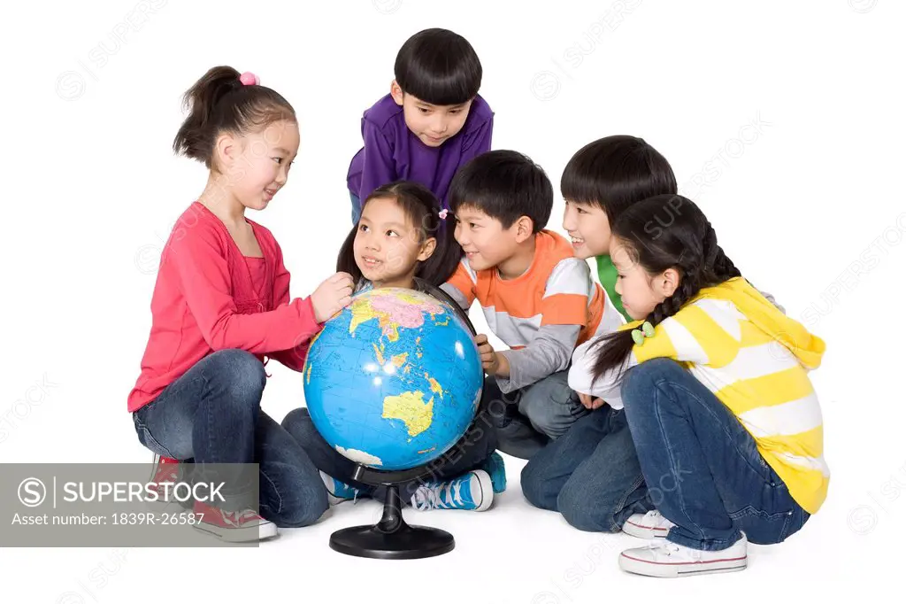 A group of sitting around a world globe