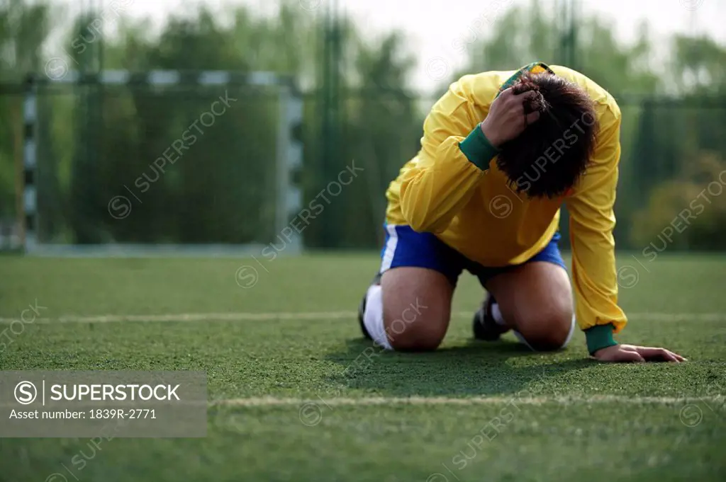 Disappointed Soccer Player On His Knees