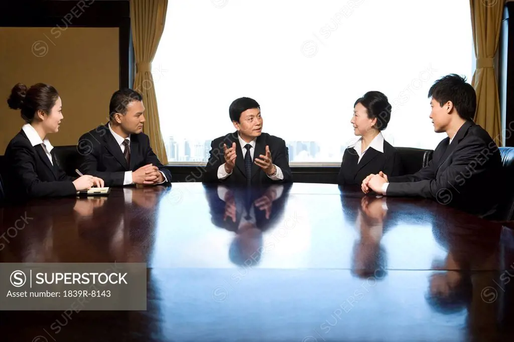 Five business professionals at conference table