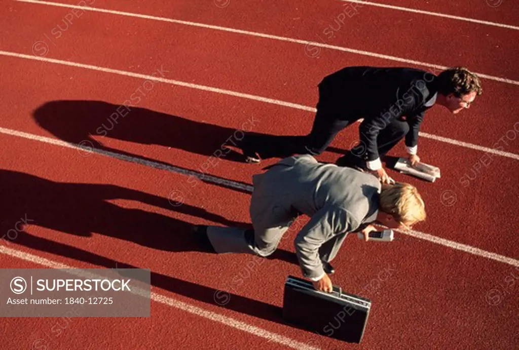 Copyright James Kay.  Businessman in starting block position on running track.