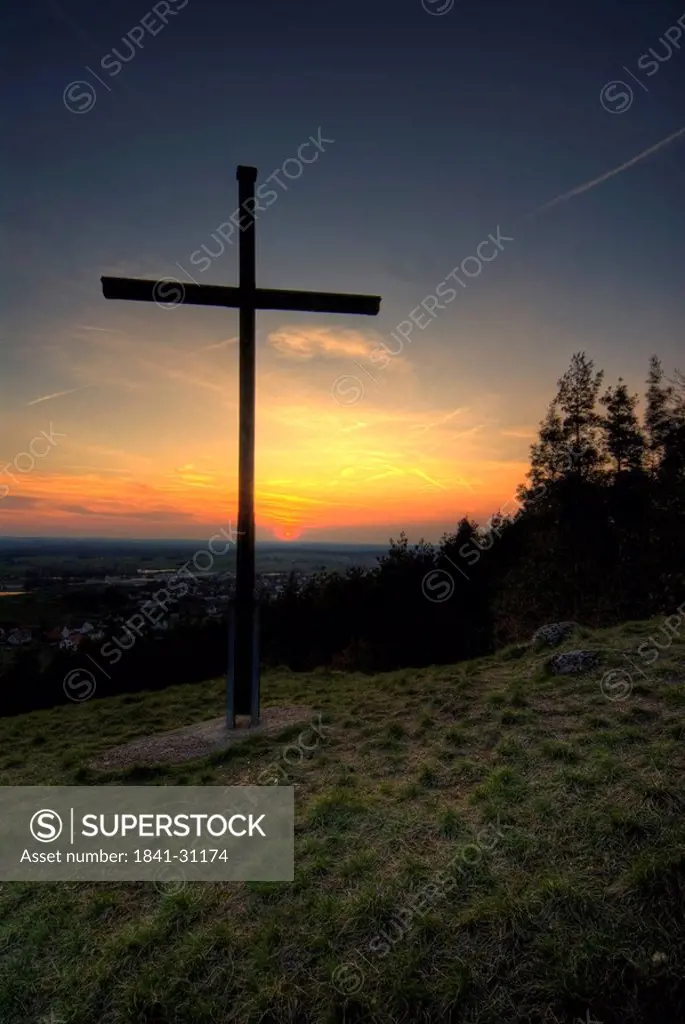 Cross in field at dusk, Germany