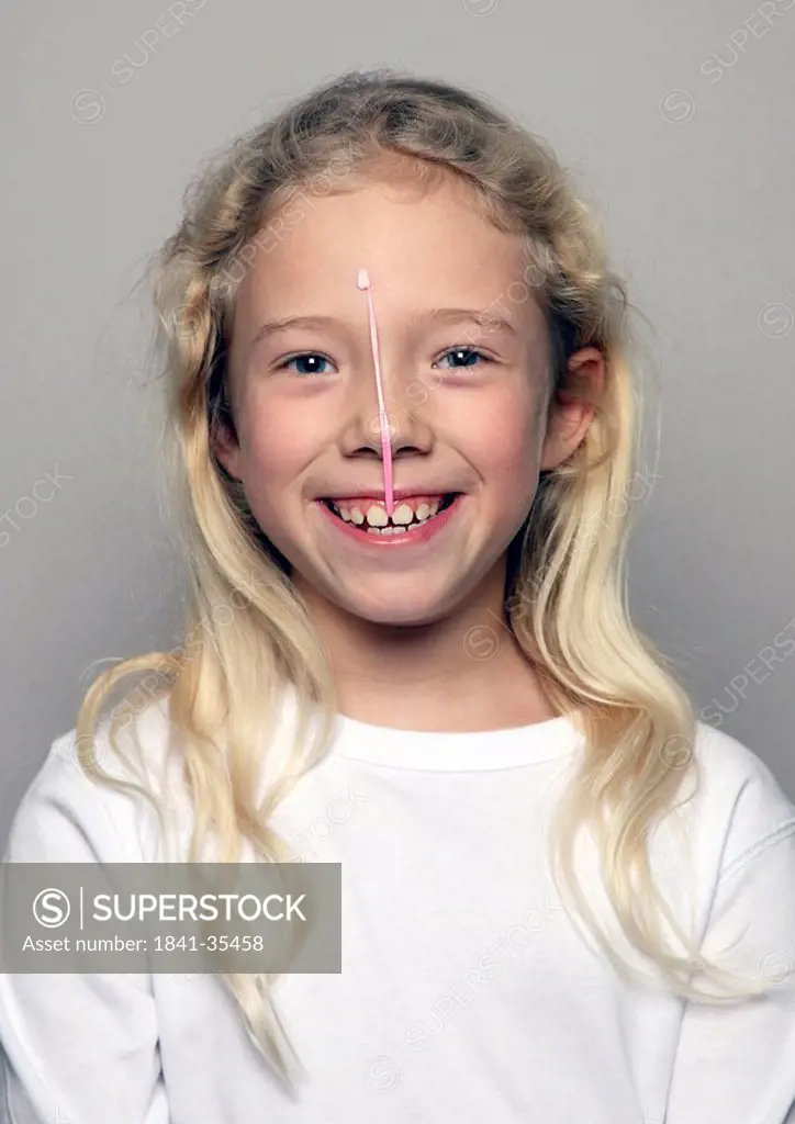 Portrait of girl smiling with burst bubble gum bubble on her face