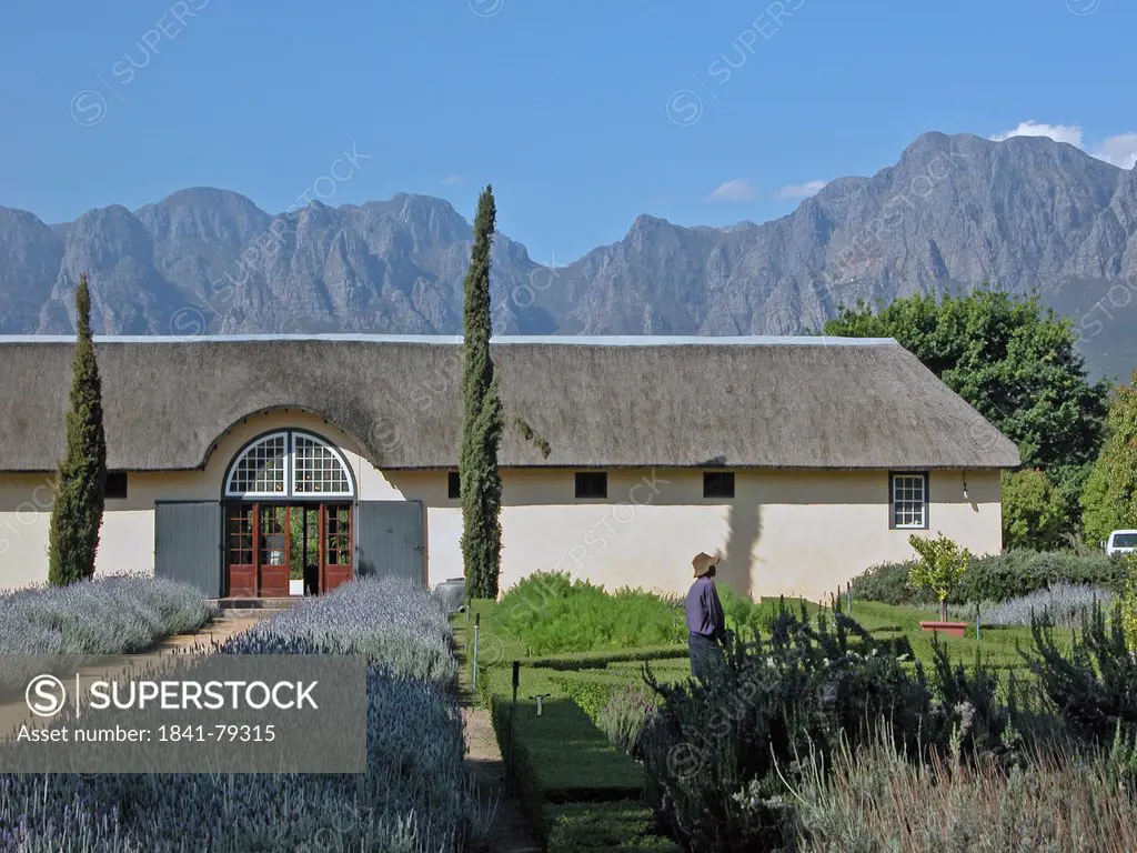 People in formal garden in front of building