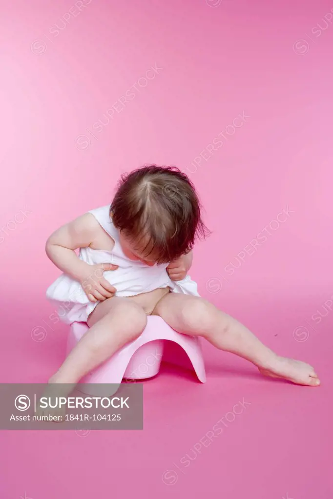 small girl sitting on her toilet