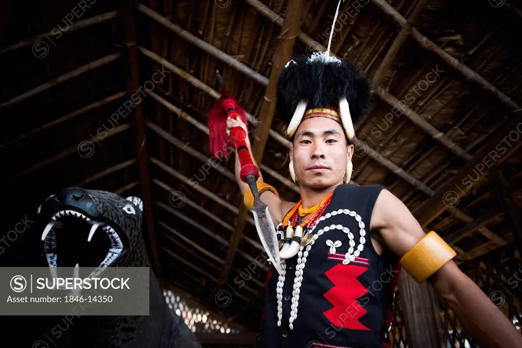 Naga tribal warrior in traditional outfit attacking with a spear, Hornbill Festival, Kohima, Nagaland, India