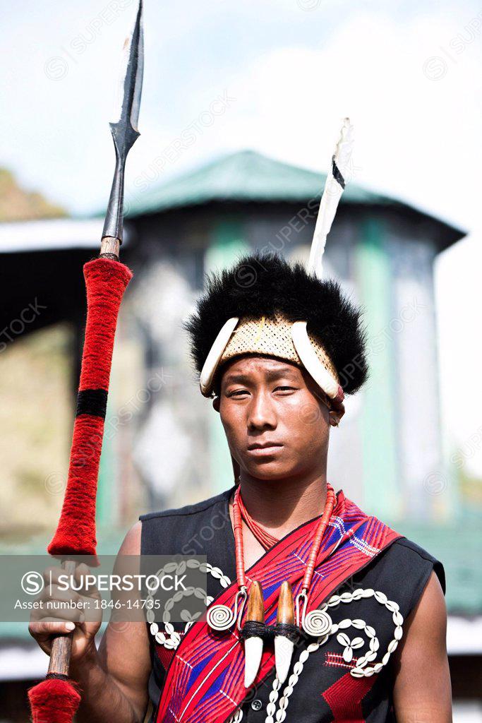 Naga tribesman in traditional outfit holding a spear during the annual ...