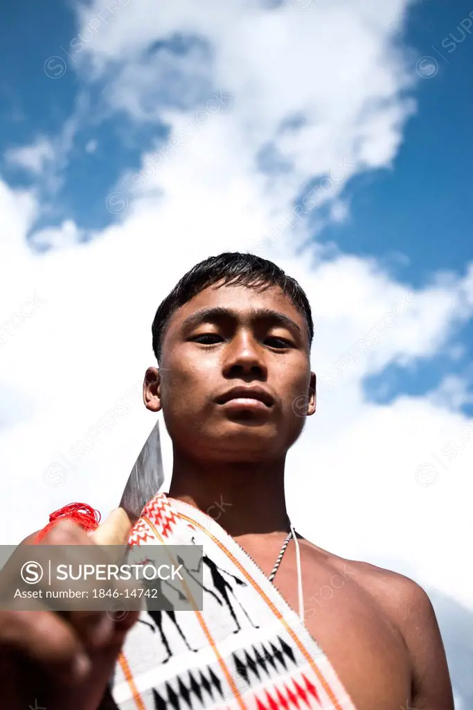 Naga tribesman holding a machete during the annual Hornbill Festival at Kisama, Kohima, Nagaland, India