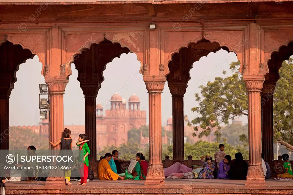 Colonnade in the courtyard of the Friday Mosque Jama Masjid, the Red Fort at the back, Delhi, India