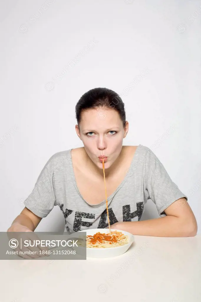 Young woman eating spaghetti