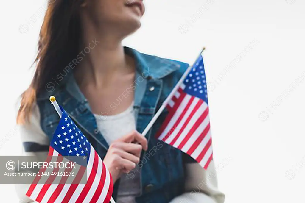 Young smiling lady holding american flags