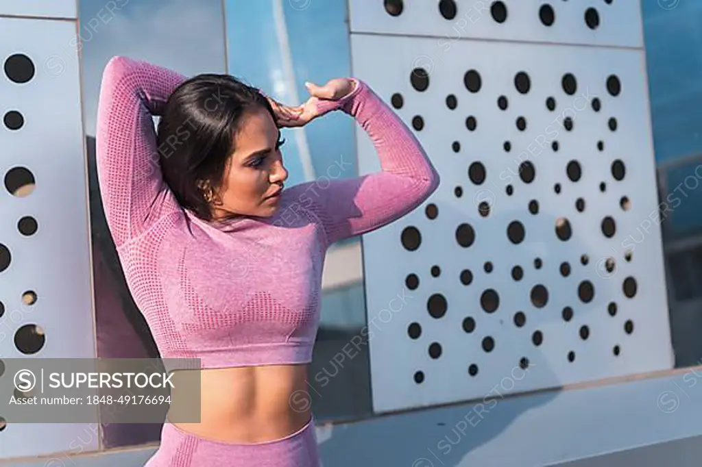 Close-up photo of a female athlete stretching before running in the city