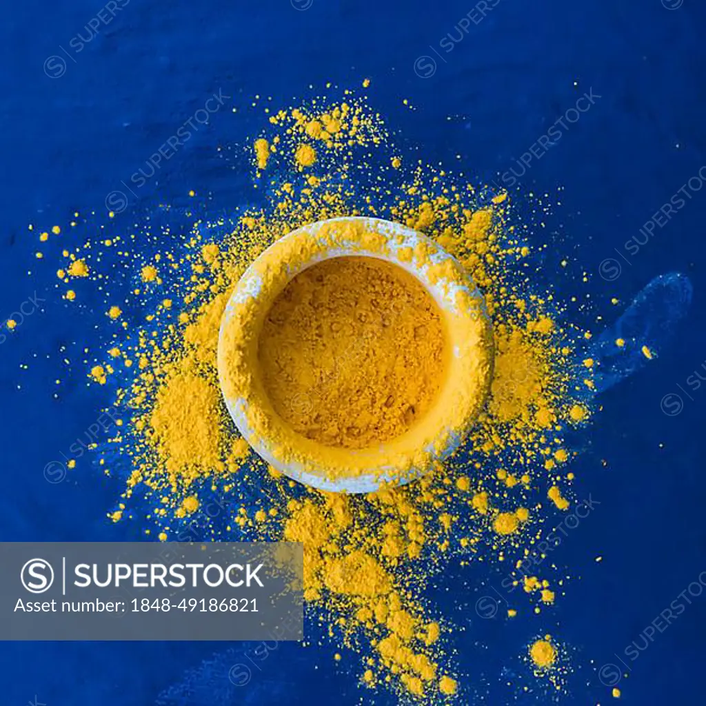 Indian holi festival yellow color bowl blue backdrop