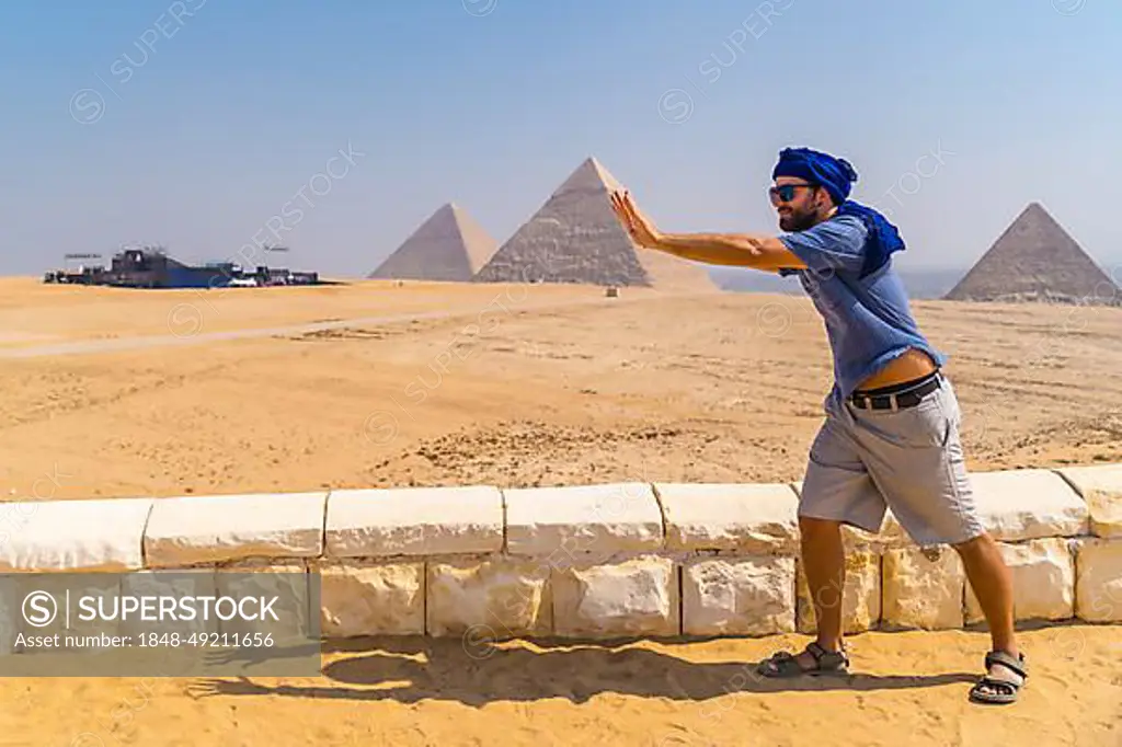 A young tourist joking at The Pyramids of Giza, the oldest Funerary monument in the world. In the city of Cairo, Egypt, Africa