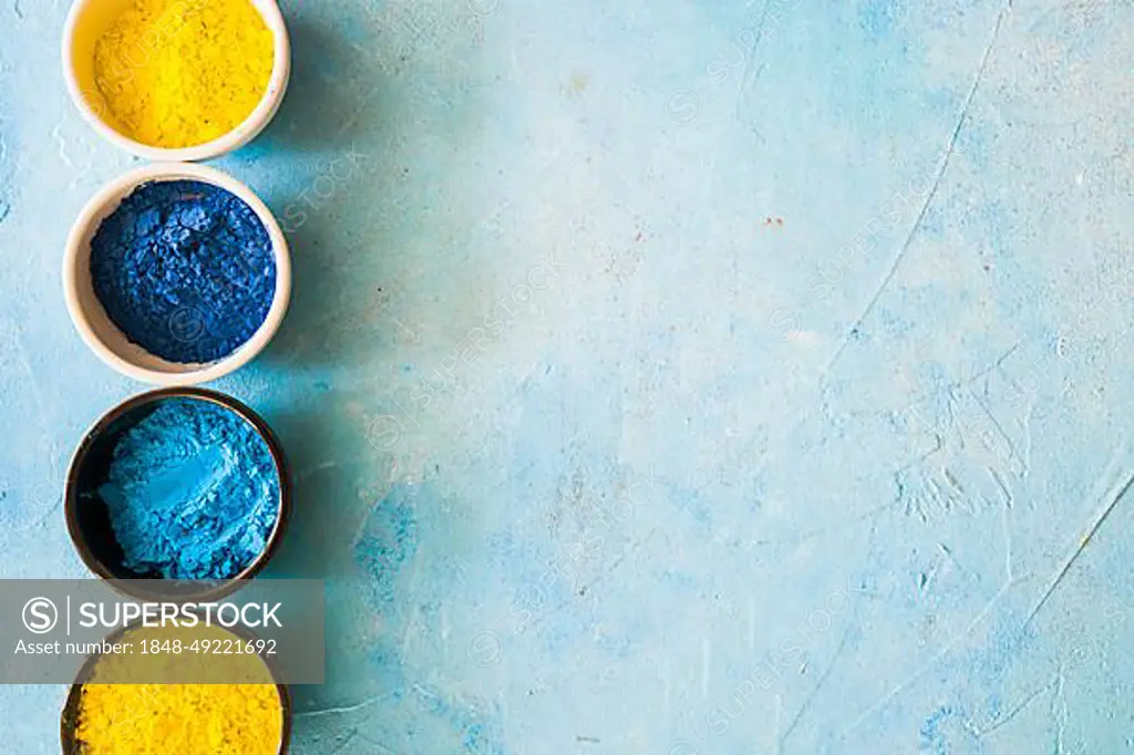 Yellow blue holi color powder bowls concrete painted background