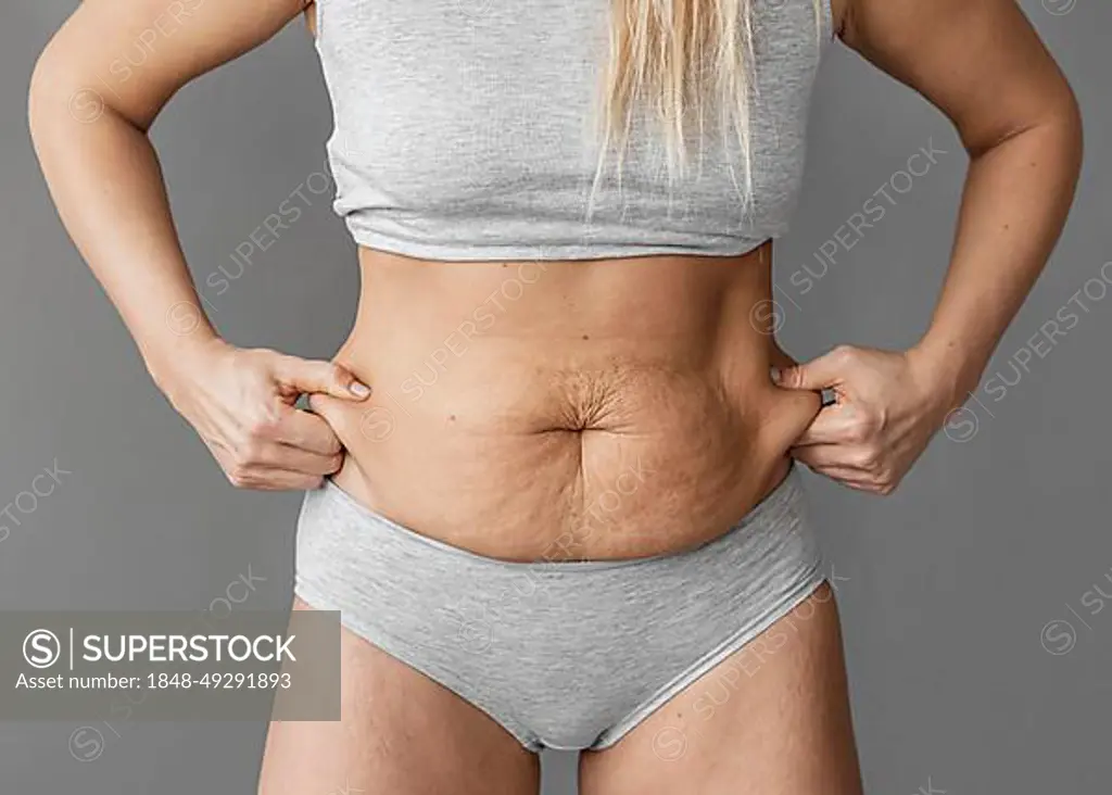 Close up woman holding belly fat