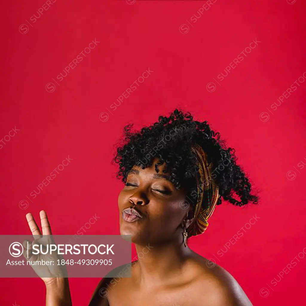 Attractive nude african young woman showing peace sign studio with bright  background - SuperStock