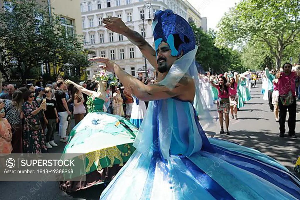 Participants in colourful outfits entertain the huge crowd before