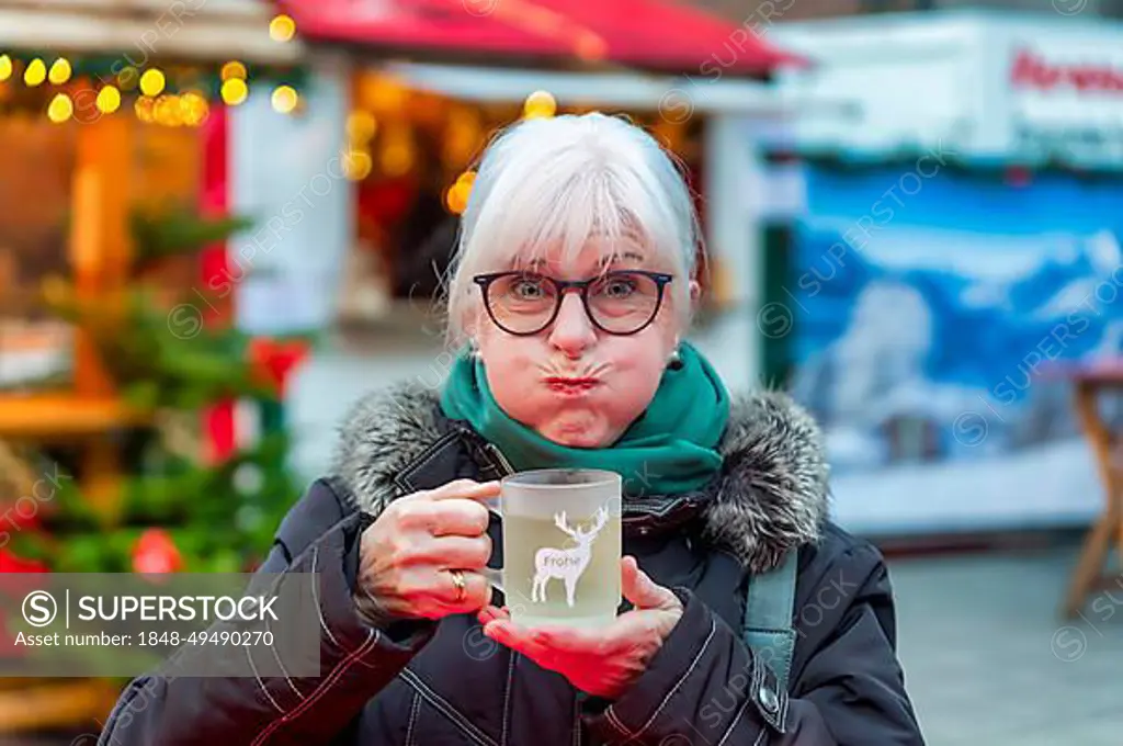 Senior citizen, camera view, frightened, horrified, drinking, mulled wine, Christmas market, Grevenbroich, North Rhine-Westphalia, Germany, public ground, Europe