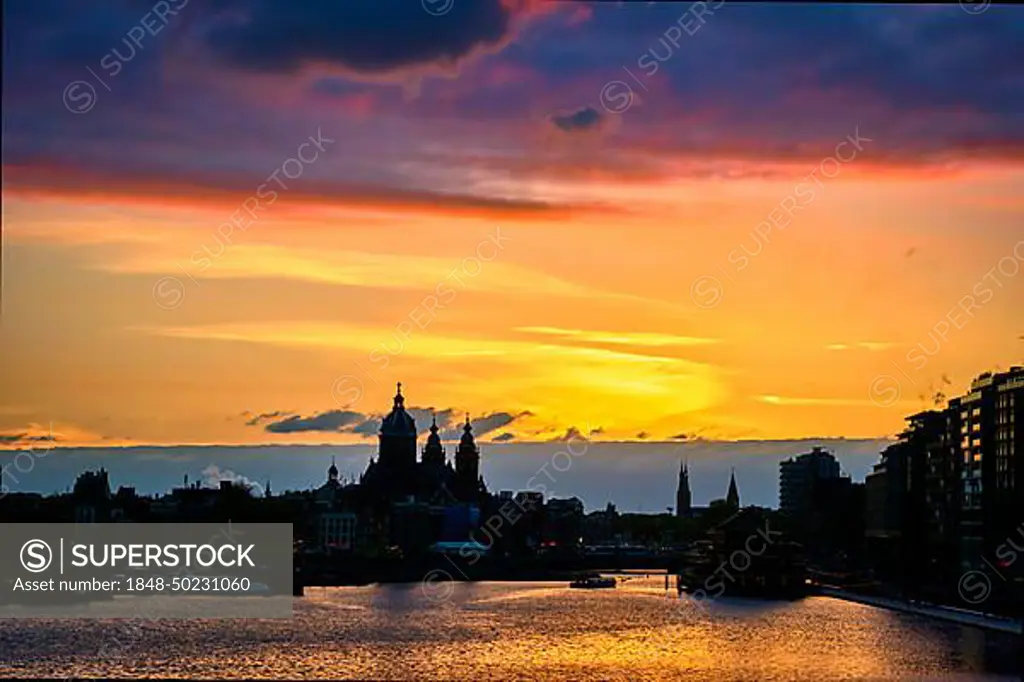 Amsterdam cityscape skyline with Church of Saint Nicholas (Sint-Nicolaaskerk) on sunset with dramatic sky. Amsterdam, Netherlands