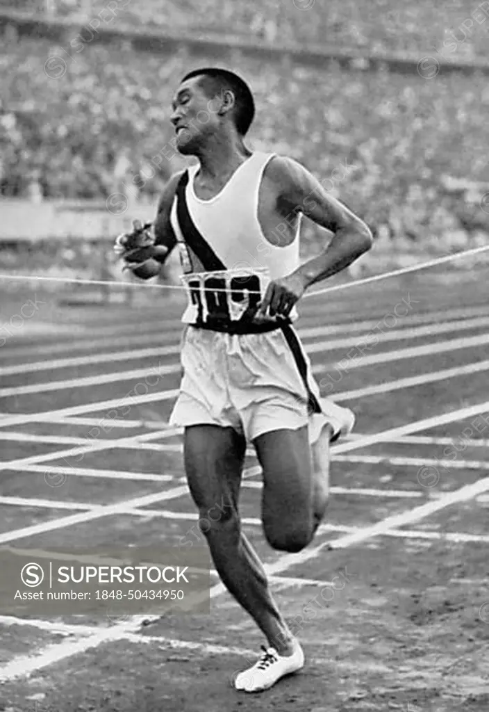 Marathon runner Kitei Son (Japan) is the first to tear the finishing ribbon in the Olympic Stadium after 42 km, marathon race