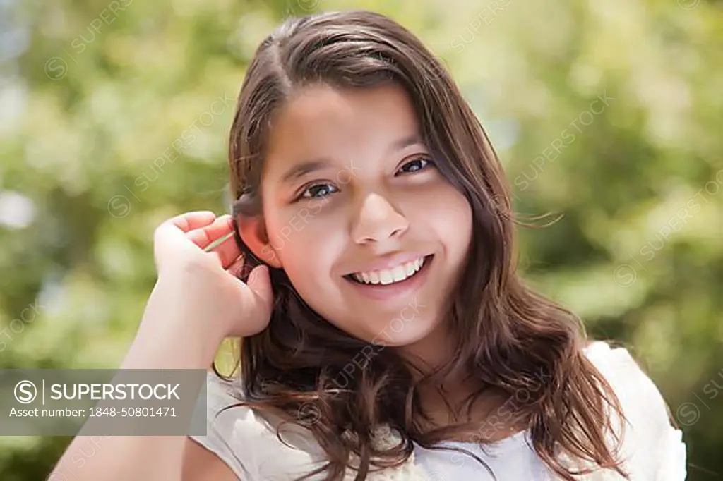 Cute happy hispanic girl portrait in the park