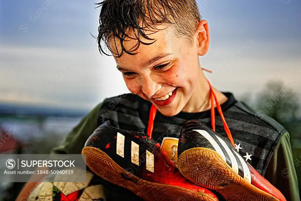 Boy with soccer shoes, Germany, Europe