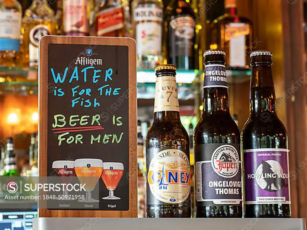 Different beer bottles and funny sign in a bar, Amsterdam, Kingdom of the Netherlands